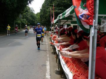 給スイカ所でランナーにスイカを手渡そうとするボランティアさん