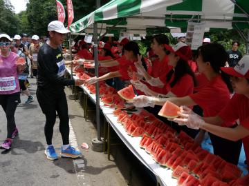 給スイカ所でランナーにスイカを手渡しているボランティアさん