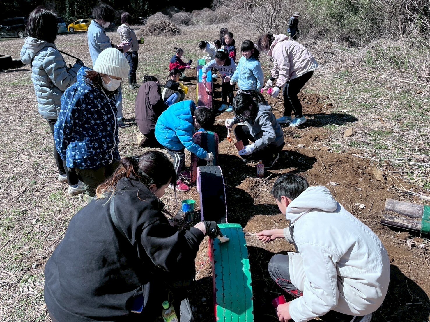 埋めたタイヤにペンキを塗っている様子