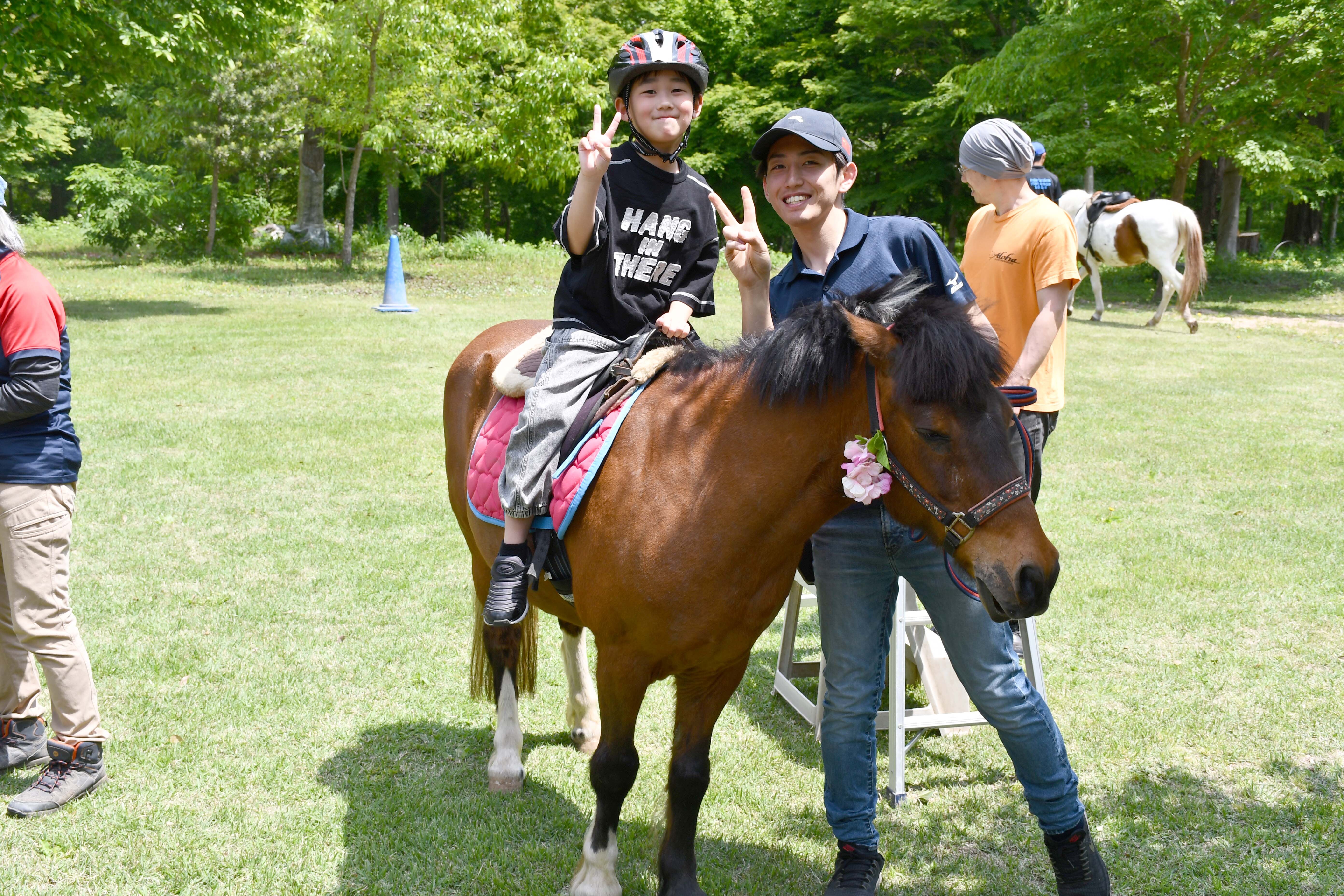 子どもが馬に乗って楽しそうにする様子
