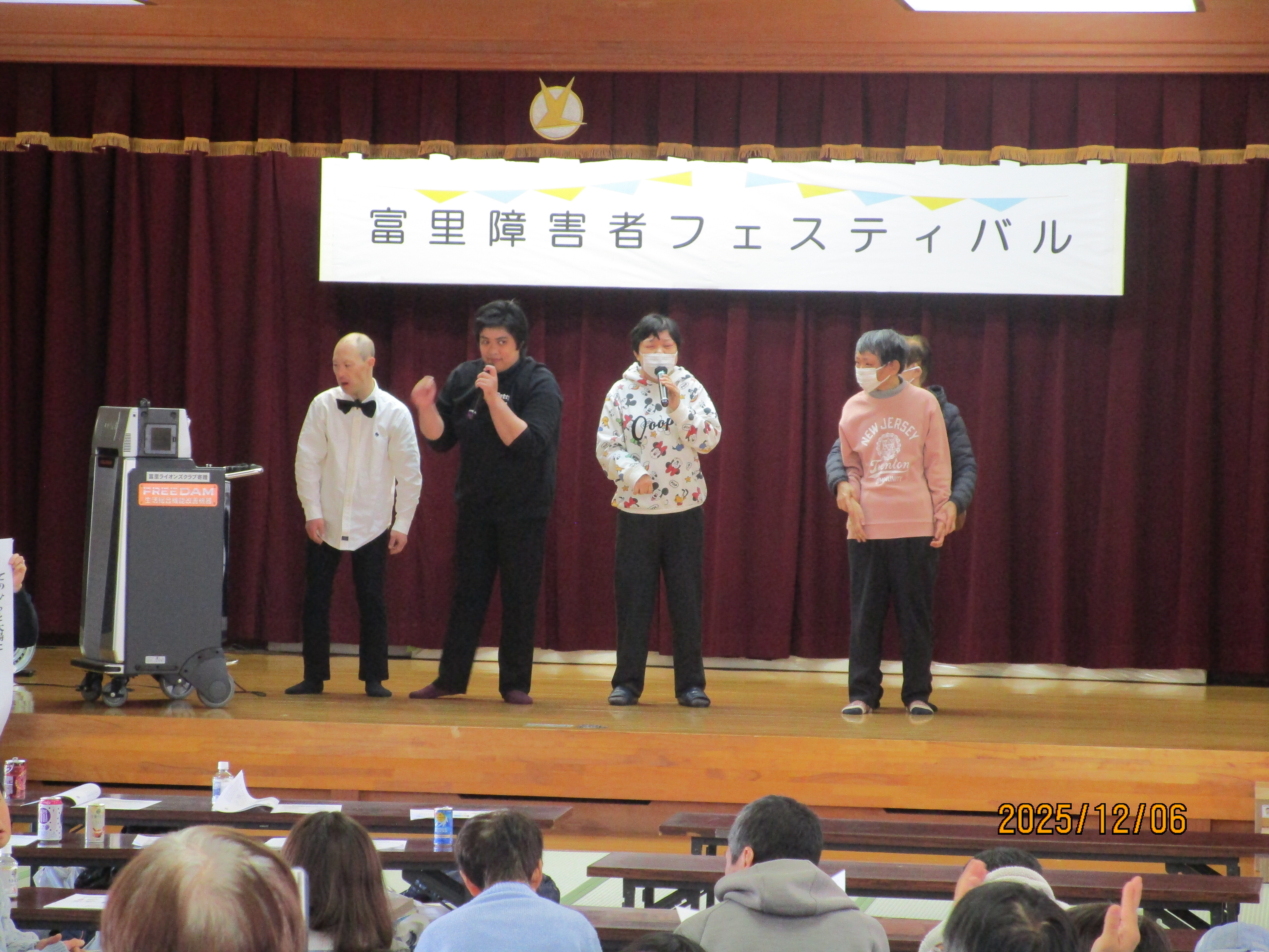 十数人が舞台の上で歌を歌っている様子