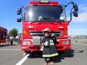 防火衣を着て消防車と記念撮影の様子